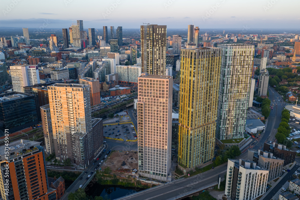 Obraz premium Aerial image of Manchester skyline featuring high-rise apartment buildings at Greengate during a morning sunrise.