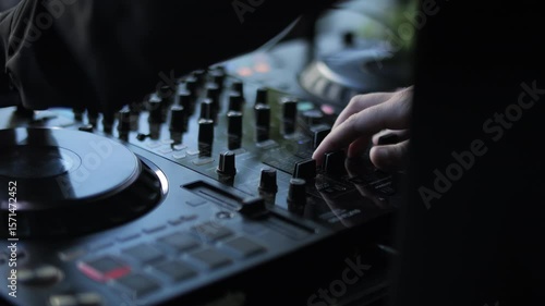 DJ mixing music on audio console outdoors