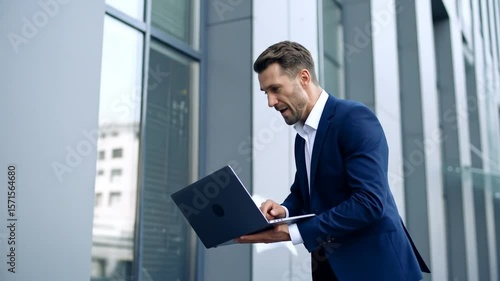 Wallpaper Mural Businessman Excitedly Using Laptop In Front Of Office Building Torontodigital.ca