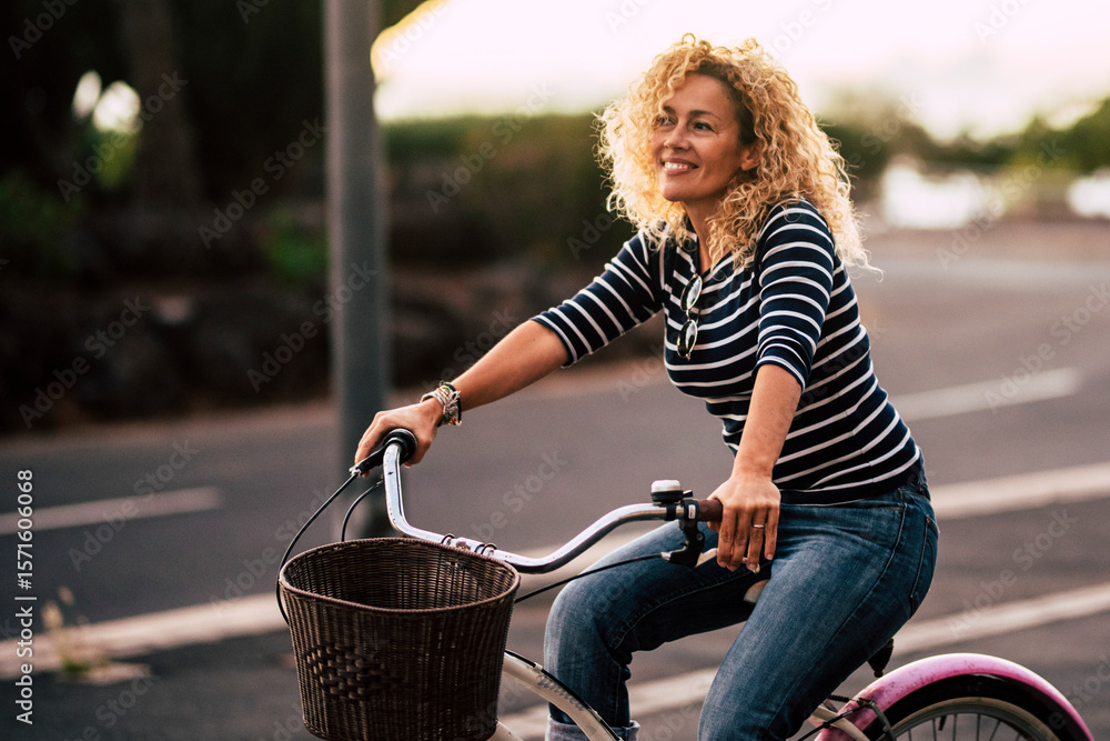 Εκτύπωση καμβά Smiling curly-haired woman in her 40s riding a city bicycle outdoors