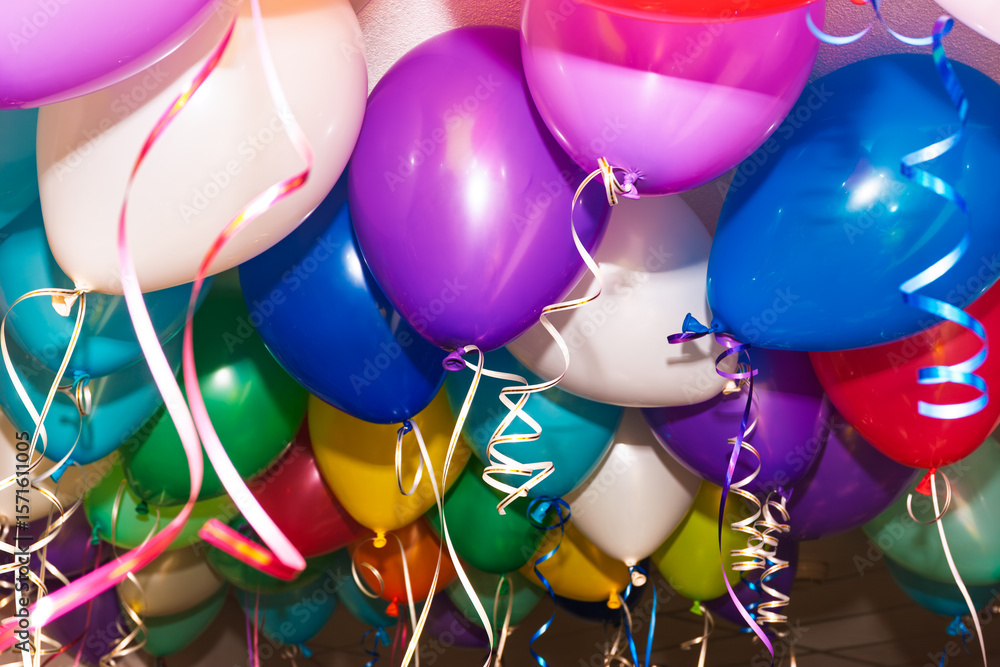 Naklejka premium Colorful helium balloons hanging during indoor festive celebration event