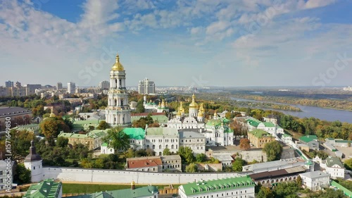 Wide aerial panorama of Kiev, Ukraine, showing the Kyiv Pechersk Lavra monastery complex, Dnipro River, city skyline, and surrounding landscape.
