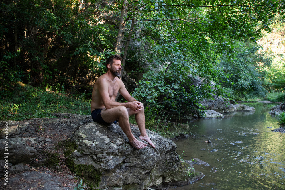 Fototapeta premium man sunbathing by the river