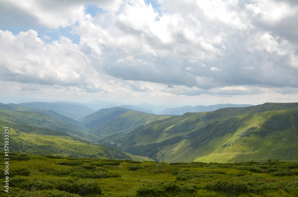 Beautiful green mountains ans hills with a mix of grasslands and shrubs spread across the horizon beneath a partly cloudy sky, embodying serenity and natural beauty. Svydovets, Carpathians, Ukraine Beautiful green mountains ans hills with a mix of grasslands and shrubs spread across the horizon beneath a partly cloudy sky, embodying serenity and natural beauty. Svydovets, Carpathians, Ukraine