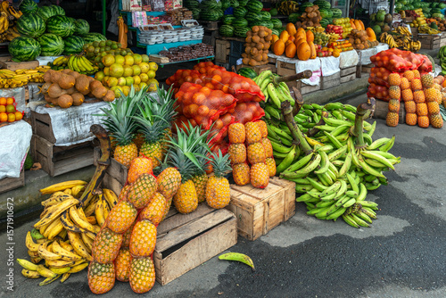 Fruit street market with pineapple, banana, water melons and other tropical fruits, Ecuador, South America.