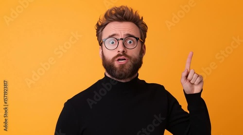 The model strikes an emphatic pose in front of an orange background.