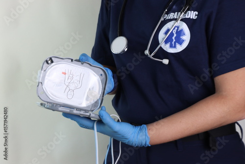 Paramedic holding a defibrillator pads in the hands to rescue in an emergency