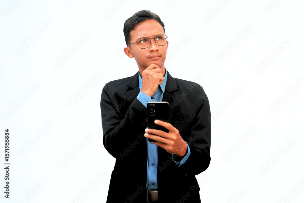An Asian business man holding a cell phone with a thoughtful expression. An Asian business man holding a cell phone with a thoughtful expression.