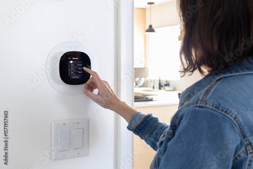 Smart thermostat. Woman setting up smart thermostat schedule.