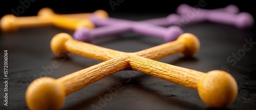 Close up view of yellow and purple dog bone chew toys arranged on a dark surface