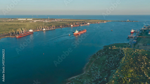 Ship departs from port, navigating through calm waters in the early morning light