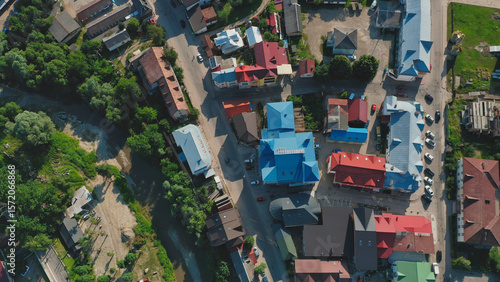 View of a township from above showcasing colorful rooftops and winding roads surrounded by greenery
