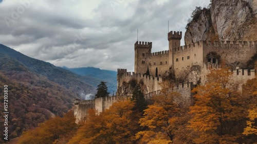 Magnificent medieval castle surrounded by autumn foliage in a mountainous region