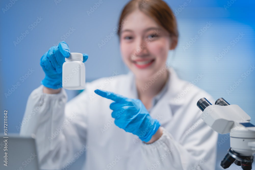 Scientist in a lab coat and gloves presenting a white pill bottle, highlighting medical research. A microscope sits nearby, emphasizing a focus on scientific discovery Scientist in a lab coat and gloves presenting a white pill bottle, highlighting medical research. A microscope sits nearby, emphasizing a focus on scientific discovery