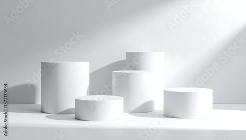 Five white cylinder podiums in sunlit studio