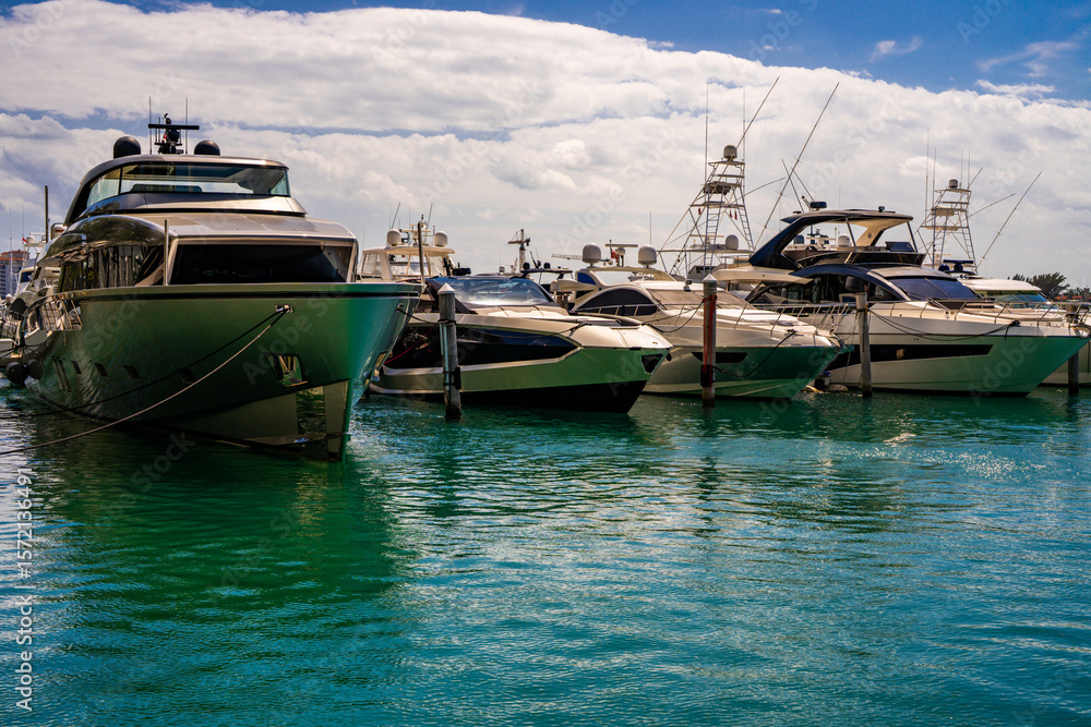 Fototapeta premium Yacht sailing on turquoise waters. Luxury superyacht at sea. Miami Beach with yachts. Tropical seascape with a sailboat. Cruise ship near the coastline. Sunset yacht voyage in Florida. Yacht in ocean.