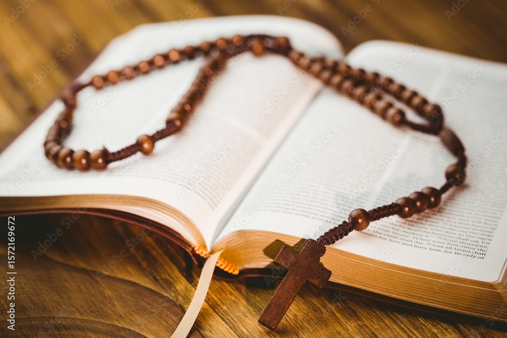Fototapeta premium High angle view of rosary beads on open bible
