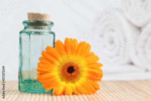 Fototapeta Naklejka Na Ścianę i Meble -  Oil with orange Gerbera daisy on table