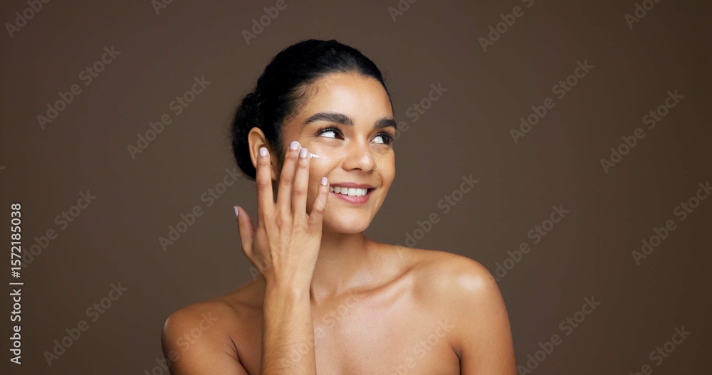 Obraz premium Thinking, woman and happy with cream, skincare or cosmetics for smooth skin, shine and mockup space. Studio background, reflection and person with smile for beauty, dermatology and facial treatment