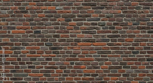 A closeup view of an aged brick wall featuring a uniform pattern of reddishbrown and grey bricks with visible mortar lines