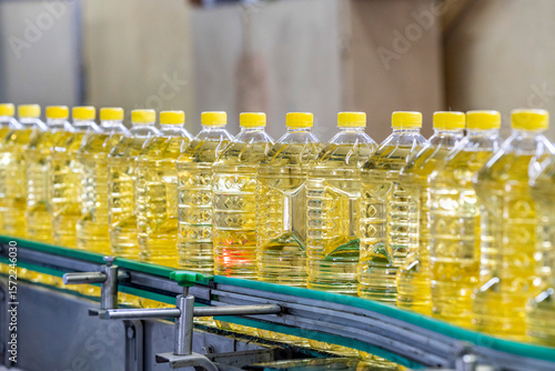 Oil in bottles. Industrial production of sunflower oil. Conveyor line for bottling and packing. Sunflower oil plant. Bottles of Cooking Oil on a Production Line.