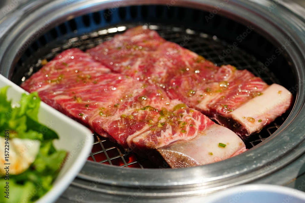Korean BBQ with Raw Beef Short Ribs Grilled on Charcoal at Local Galbi Restaurant Korean BBQ with Raw Beef Short Ribs Grilled on Charcoal at Local Galbi Restaurant