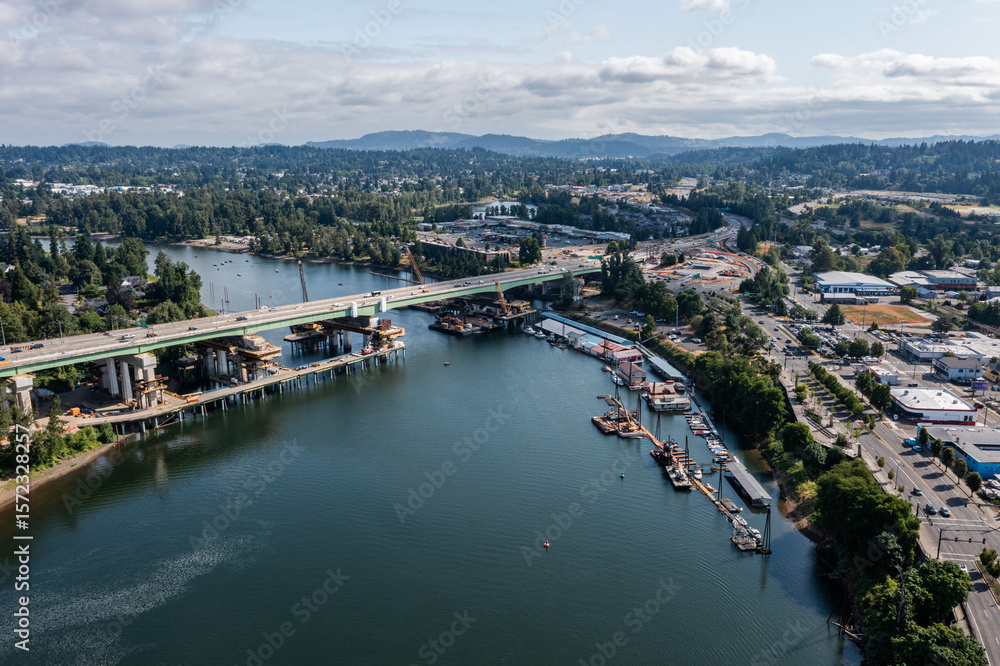 Fototapeta premium Aerial drone picture of Abernethy Bridge and I-205 highway over the Willamette River, connecting Oregon City and West Linn, Oregon, with construction barges, traffic, and scenic surroundings