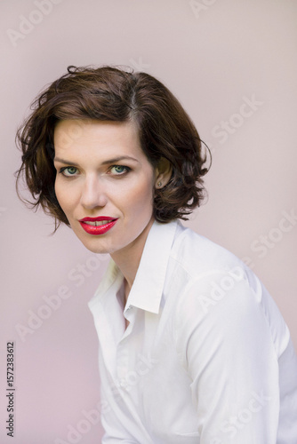 Studio portrait of beautiful young woman with blue eyes and short brown hair
