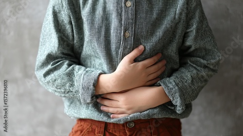 Child rubbing his belly, showing signs of indigestion. 