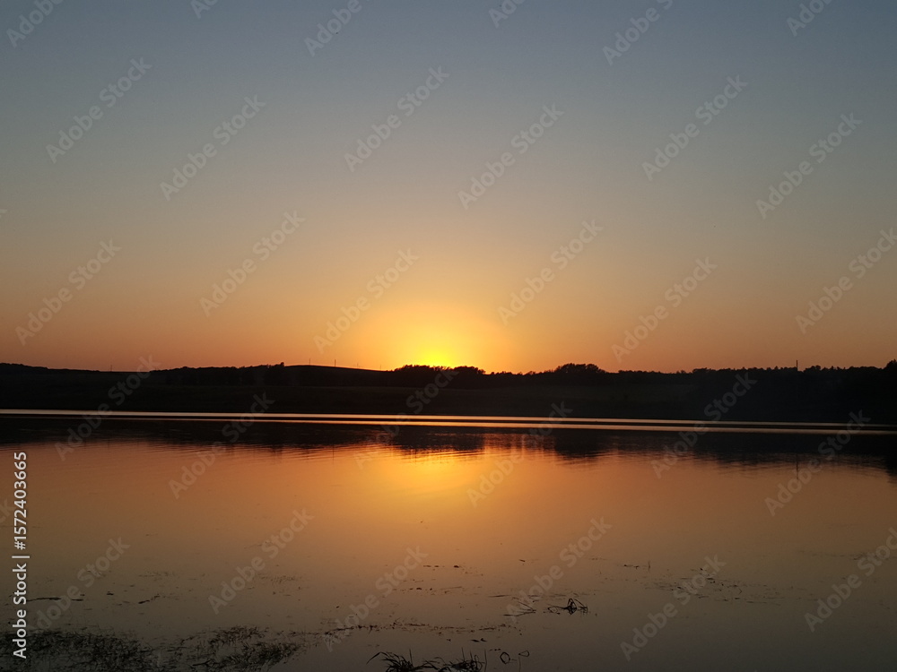 Naklejka premium sunset over the lake in summer