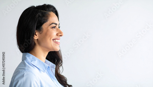 Side view of a Middle Eastern woman smiling brightly against a white isolated background.