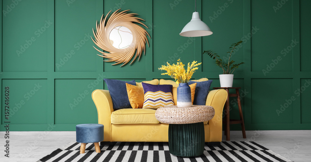 Obraz premium Interior of stylish living room with yellow sofa, poufs and mirror
