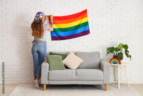 Young woman hanging LGBT fl...