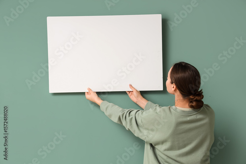 Young woman holding blank p...
