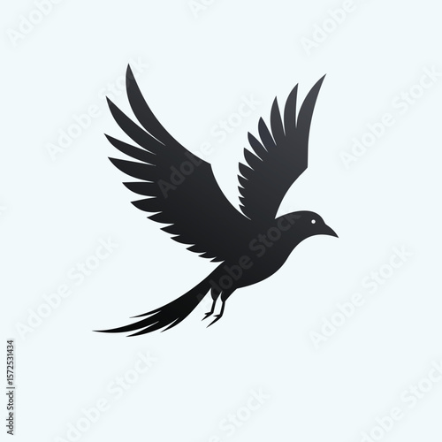 Elegant silhouette of a black bird in mid flight with wings spread wide against a clean white background