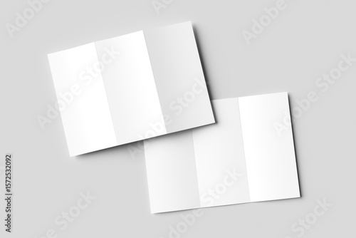 Two blank white tri-fold brochure mockups, slightly overlapping on a light gray background. One is partially open, the other closed. Ideal for clean design presentations
