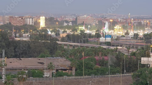 Day to Night Timelapse of Seville Skyline with Illuminated Fairground Rides at Sevilla Fair