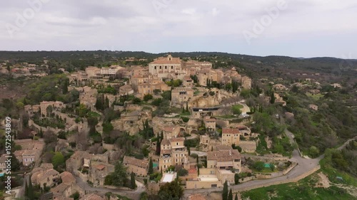 Aerial view of medieval Gordes clinging to cliffs above rural Provence