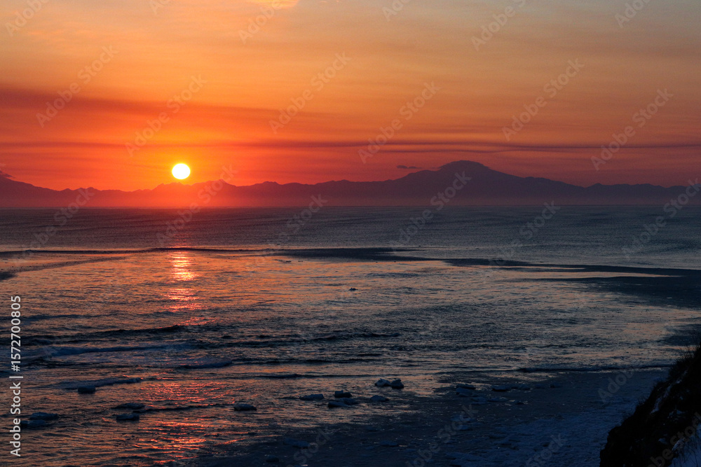 Fototapeta premium Vibrant Sunrise Over a Snowy Winter Seascape