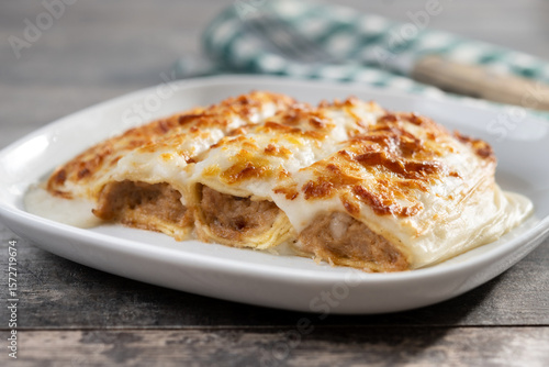 Fotografía Baked meat cannelloni with Cheese and Béchamel Sauce on wooden table