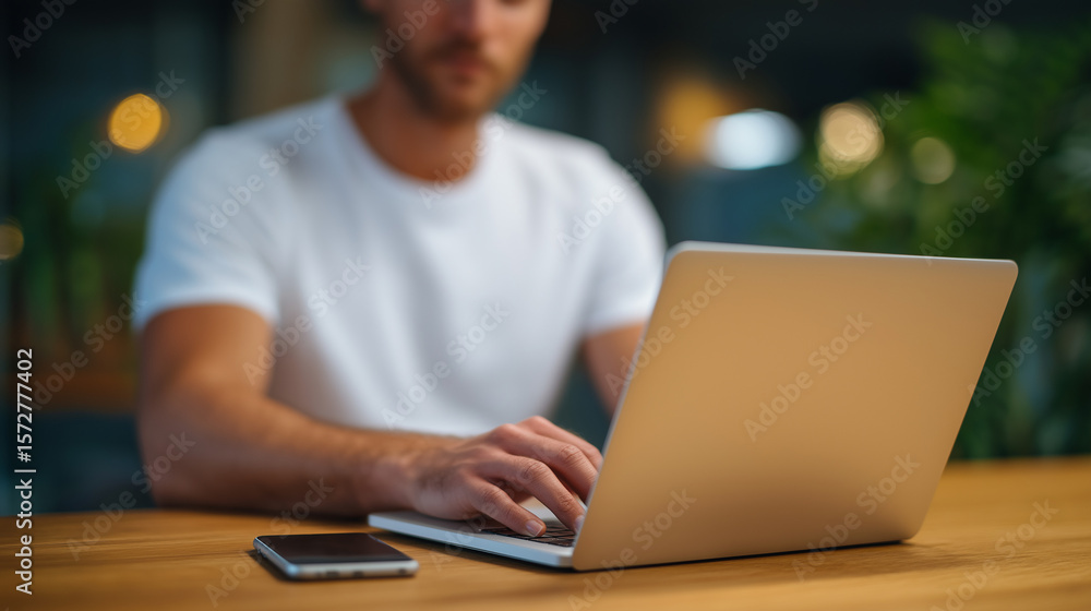 Person working on a laptop at a wooden desk in a modern office Person working on a laptop at a wooden desk in a modern office