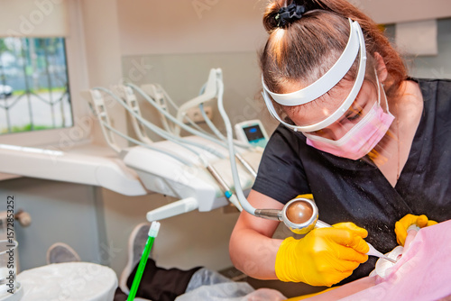 Dentistry. Professional dentist does hardware teeth cleaning with Air Flow for a patient.