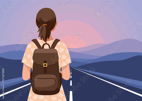 A girl with a backpack in the early morning stands on the road and looks at the sunrise