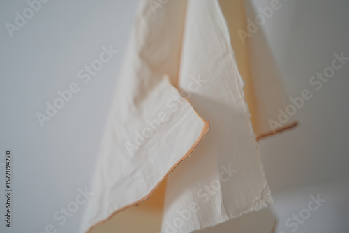 Wallpaper Mural A close up shot of a folded cream colored cloth hanging against a light colored wall backdrop indoors Torontodigital.ca