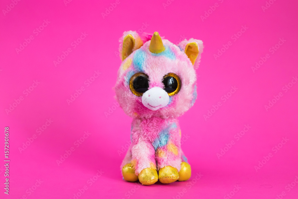 Obraz premium Toy cartoon koala sits on a white gift box on a pink background