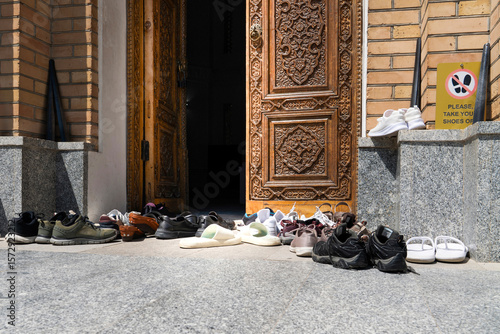 There is a warning to take off your shoes at the entrance of the mosque and many shoes are placed in front of the door, Samarkand, Uzbekistan