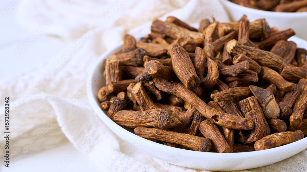 Obraz premium closeup macro pile of dry dandelion root herb for loose tea in bowl on white table background with copy space