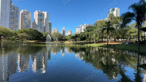 Amazing video of Flamboyant Park with a beautiful lake, swimming ducks and a reflection of modern buildings and nature in the water. Goiania, Goias, Brazil 