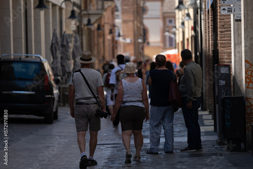 Wallpaper Mural Tourists and locals walking through a narrow cobblestone street in Europe Torontodigital.ca