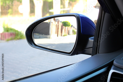Blue rearview car driving mirror. Side rear-view mirror on a modern car.  Look in the rear view mirror of a car. Accessory for vehicles to look back on road for good visibility and drive car safely.